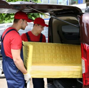 Günstig umziehen in Königstein Günstig umziehen in Königstein: Umzugshelfer laden ein gelbes Sofa in einen Transporter