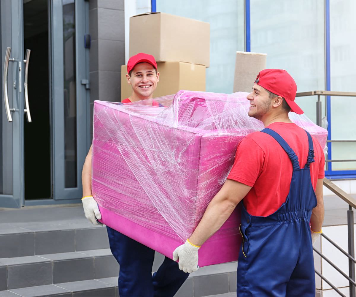 Umzugsunternehmen Königstein: Zwei Umzugshelfer tragen ein in Folie gepacktes Möbelstück für den Umzug nach Moldau