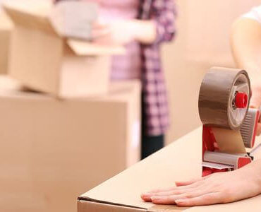 Verpackungsmaterial Verpackungsmaterial: Hand verklebt einen Umzugskarton mit Klebeband